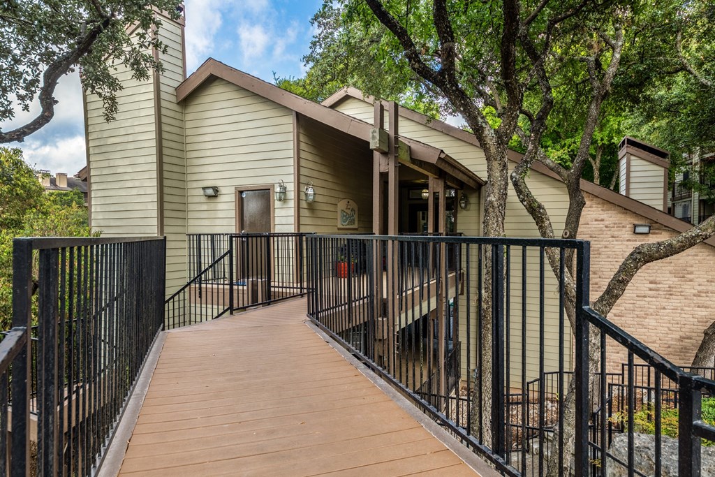 the deck of a building with a fence and a tree