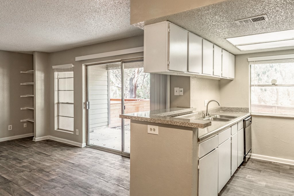 an empty kitchen with a sliding glass door to a patio