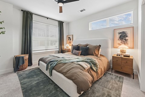 A bedroom with a large bed and a ceiling fan at Whispering Pines at Westdale Hills in Euless, TX