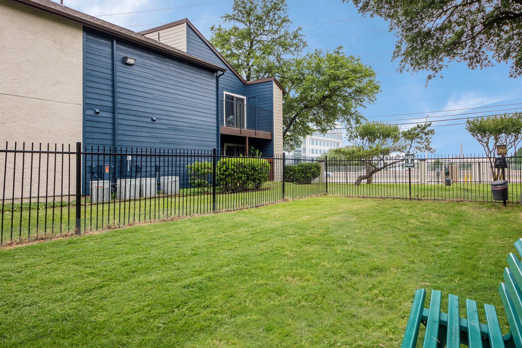 the back yard of a house with a fence and a bench