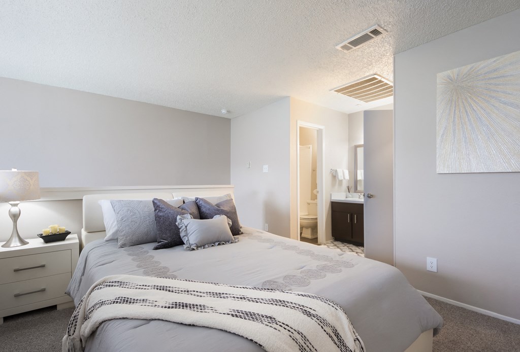 a bedroom with a large bed and a bathroom with a sink