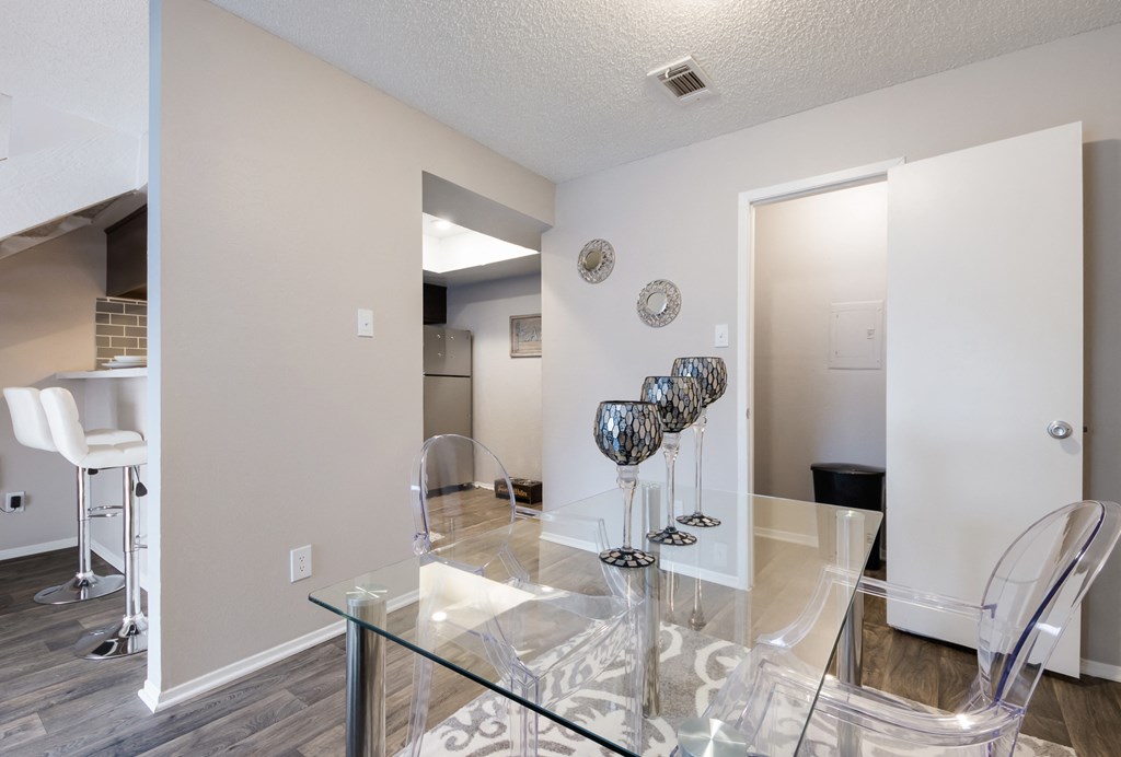 a dining room with a glass table and chairs