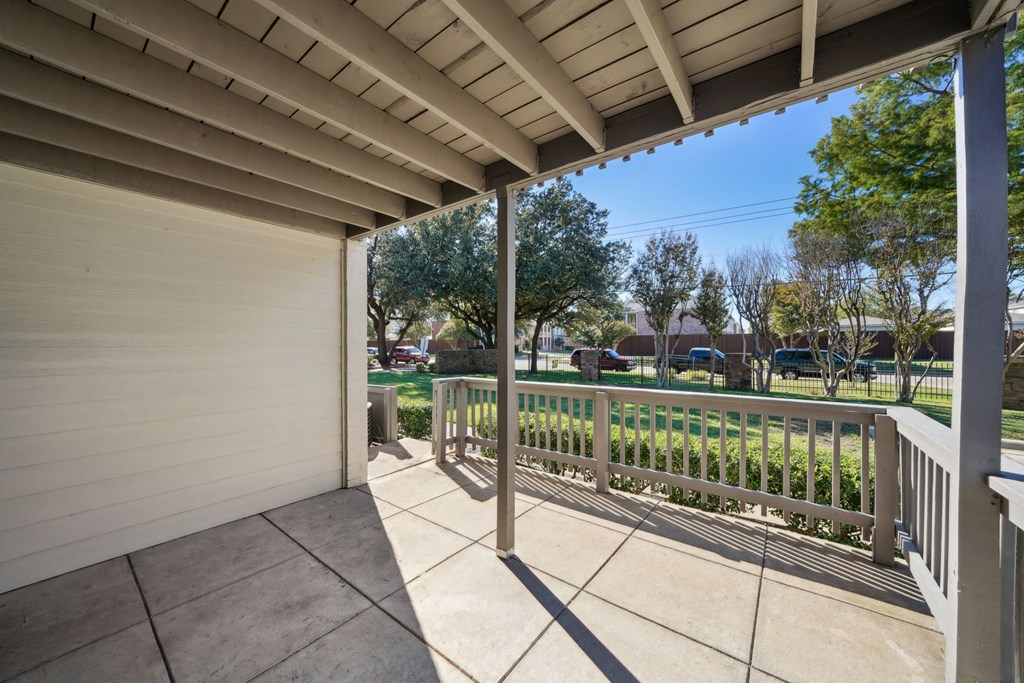 a view to the green area from the covered porch at Woodlands of Plano in Plano, TX