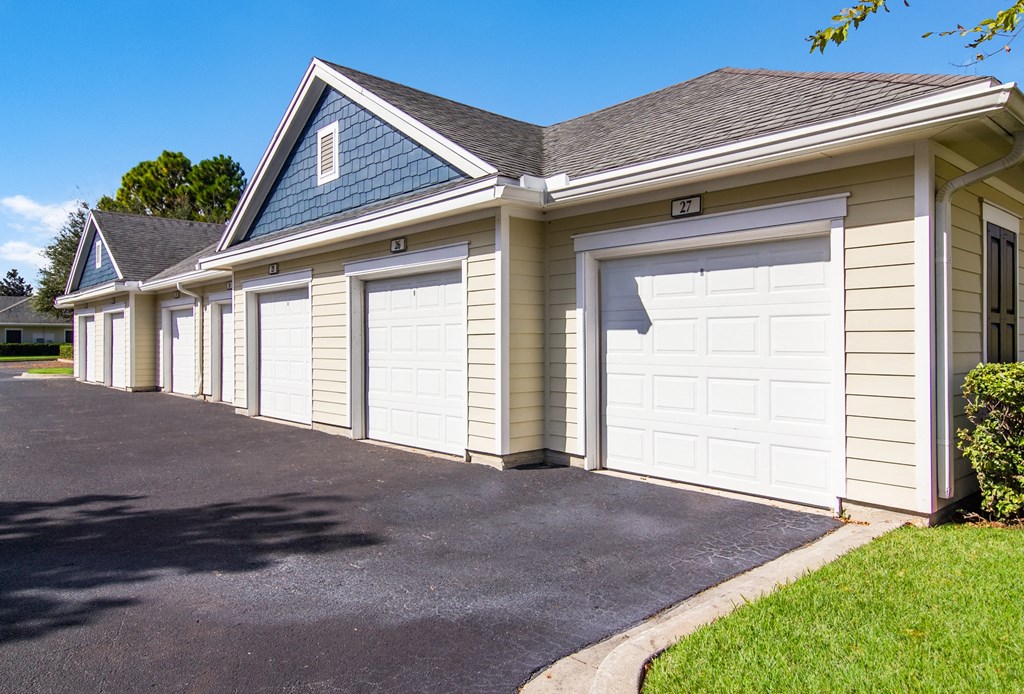 a white garage with two white doors on the side of a house
