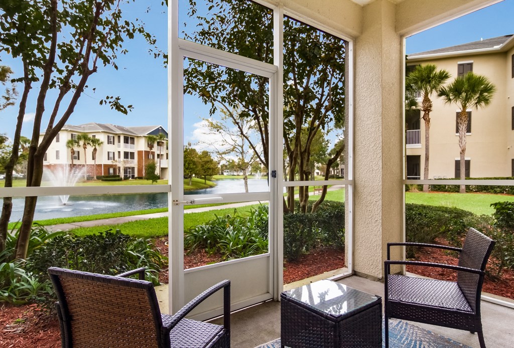 a patio with a table and chairs and a large window