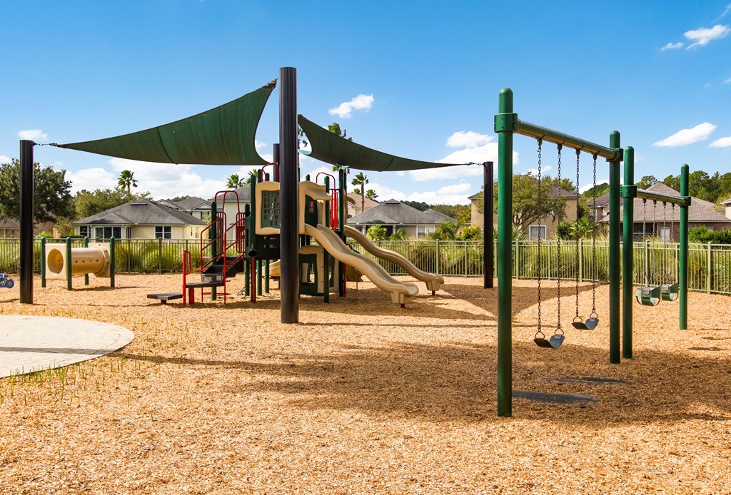 a playground with a jungle gym and slides in a park