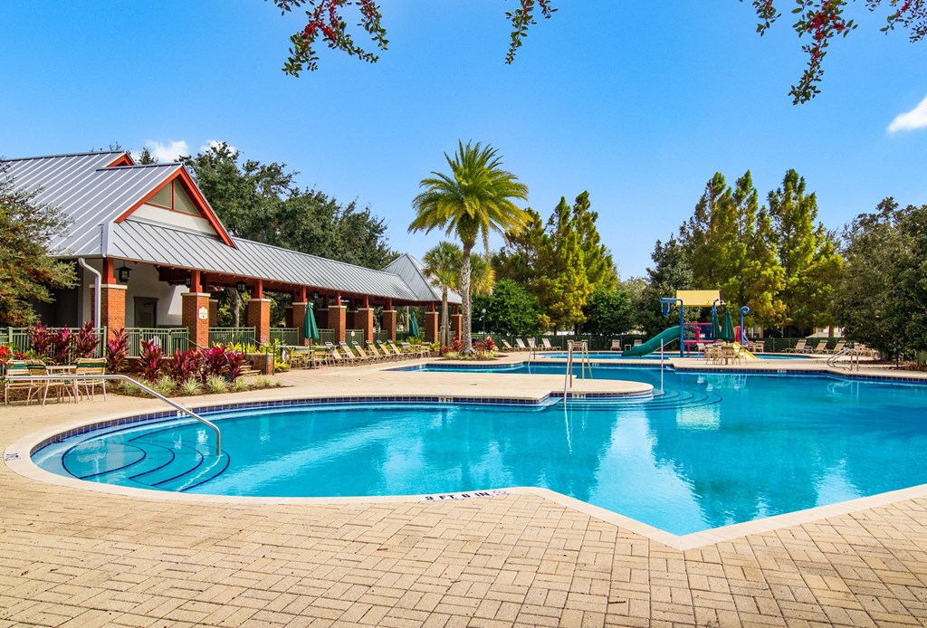 a large swimming pool with a resort style pool house and water slides
