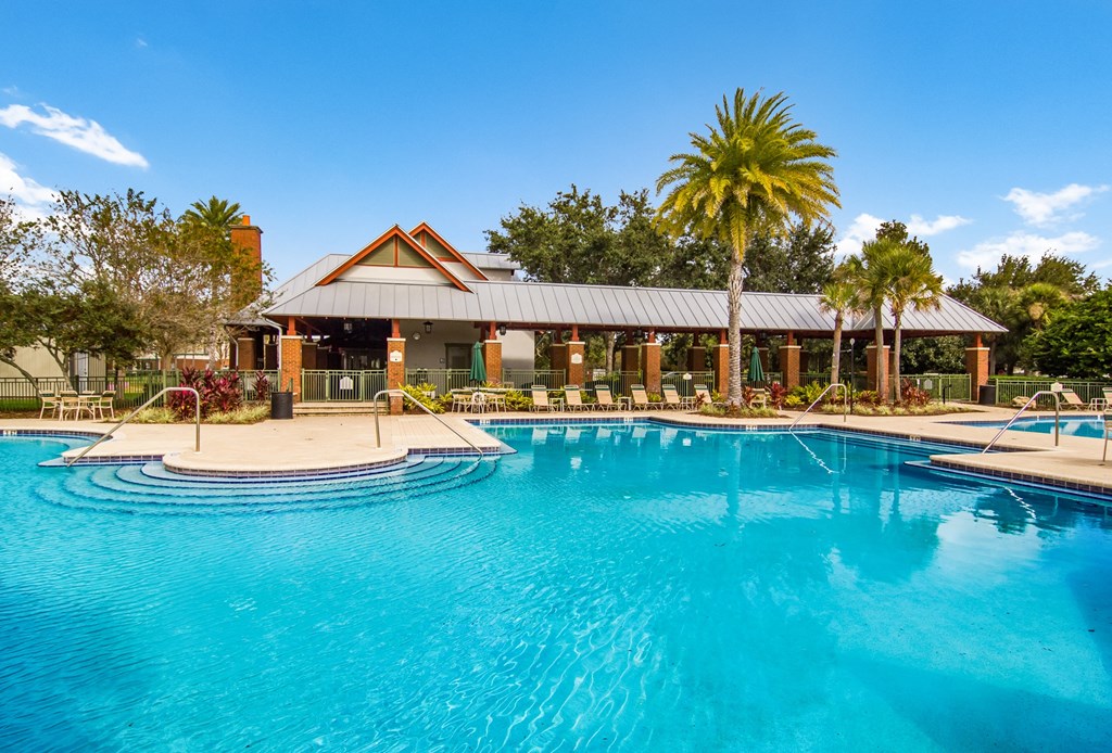 a large swimming pool with a house in the background