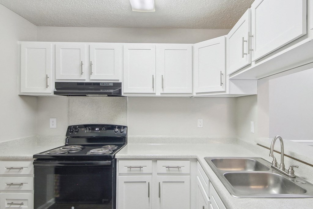 Kitchen with white cabinets and black appliances at Arrowood Crossing Apartments in Charlotte, NC