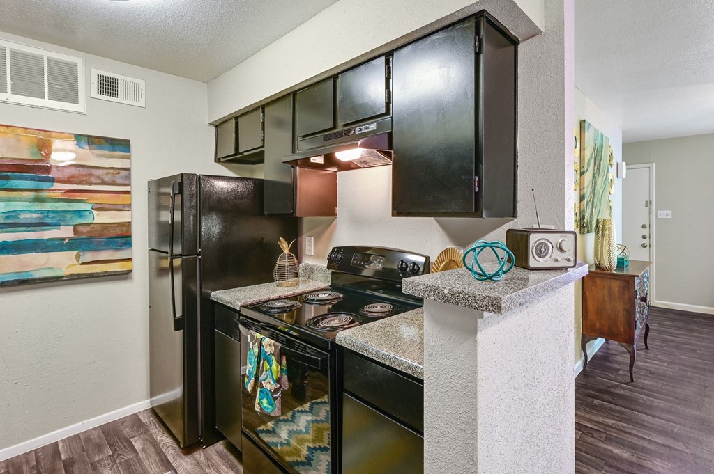 a kitchen with a stove top oven next to a refrigerator