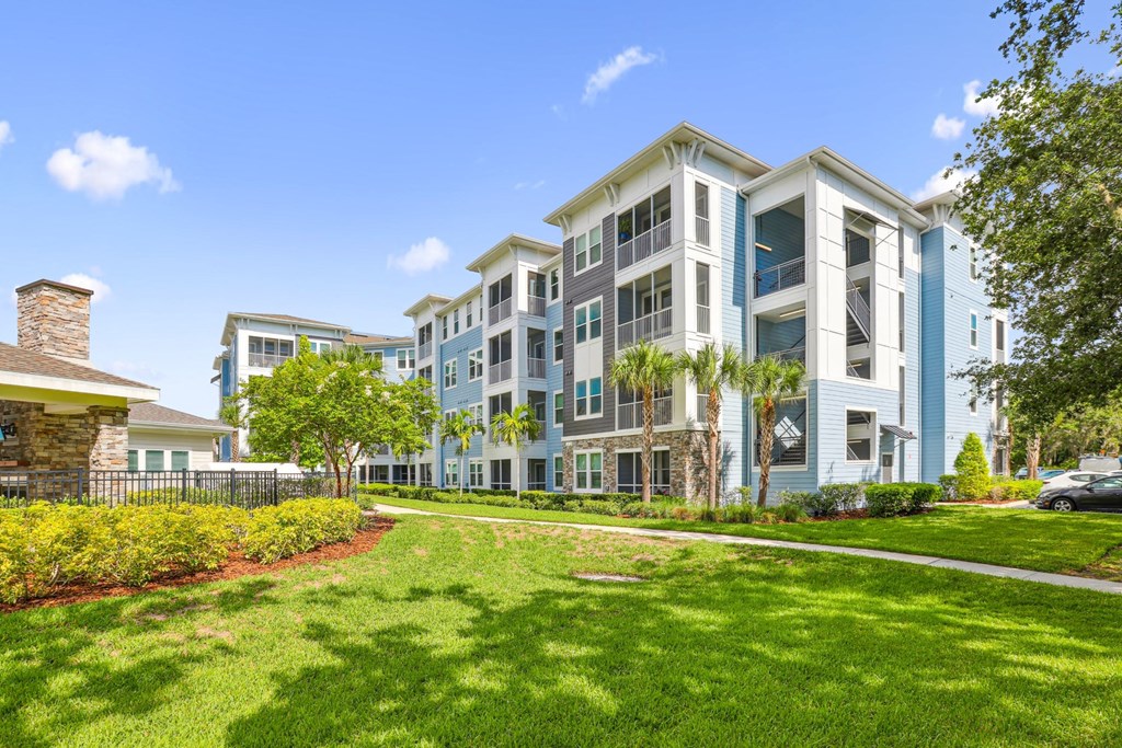 Our large luxury apartment buildings with a green lawn in front of it at Dunedin Commons apartments in Dunedin, FL