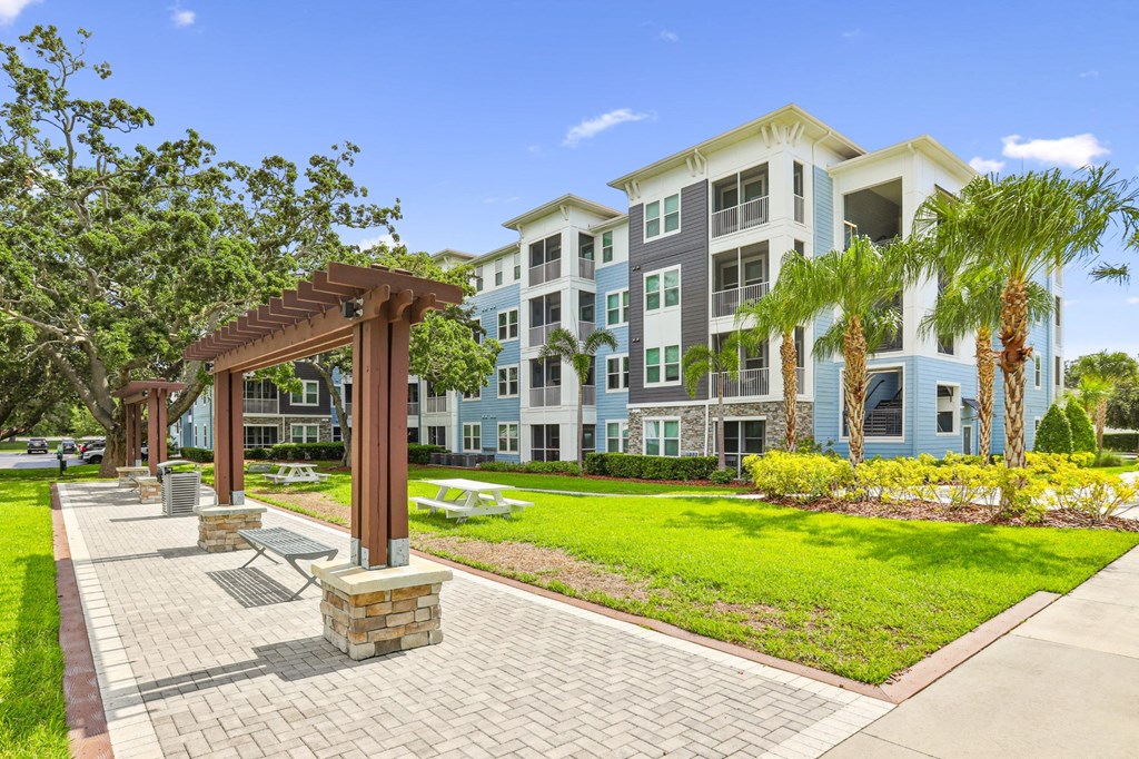 Bench seating by sidewalks and apartment buildings at Dunedin Commons apartments in Dunedin, FL