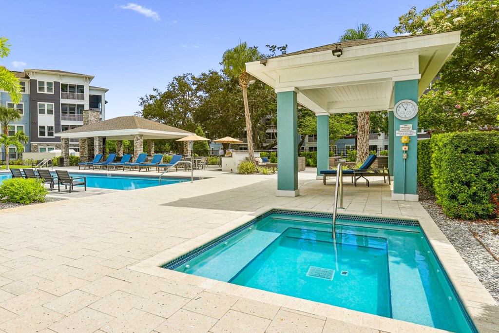 Jacuzzi with shaded seating area by the pool at Dunedin Commons apartments in Dunedin, FL