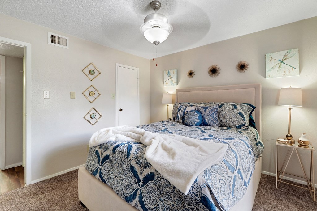 a bedroom with a bed and a ceiling fan