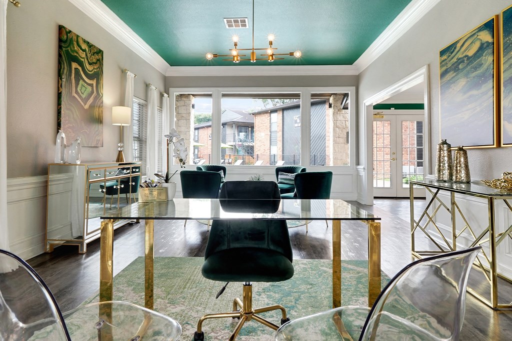 a dining room with a glass table and black chairs