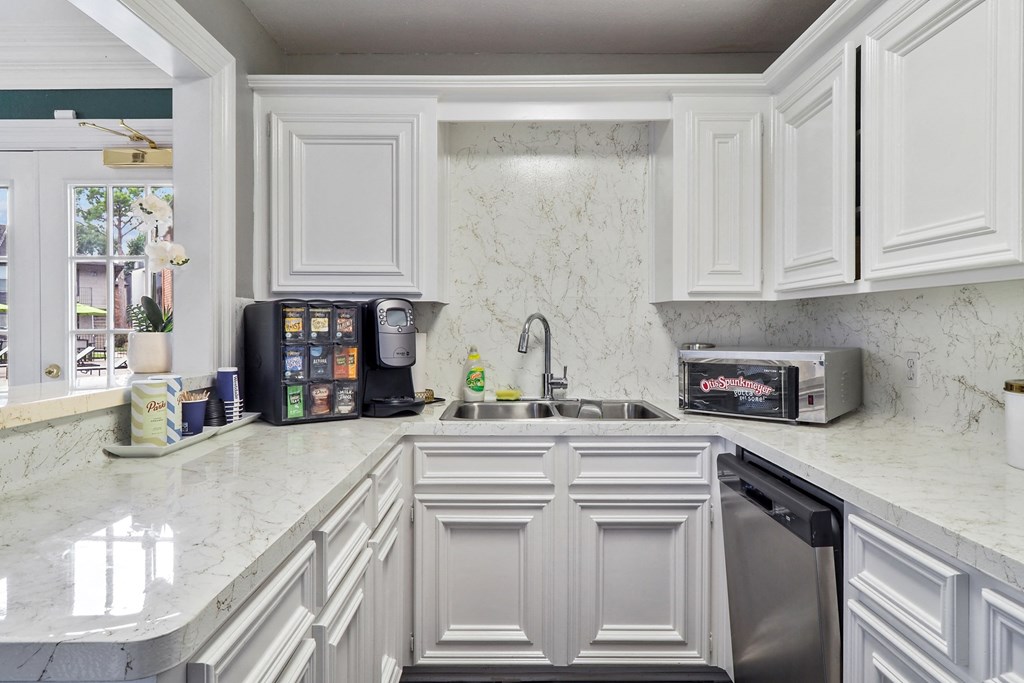 a kitchen with white cabinets and a white counter top