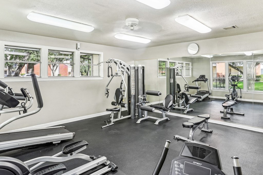 Fitness center with cable weight machines and cardio equipment at Hunters Chase in Austin, TX