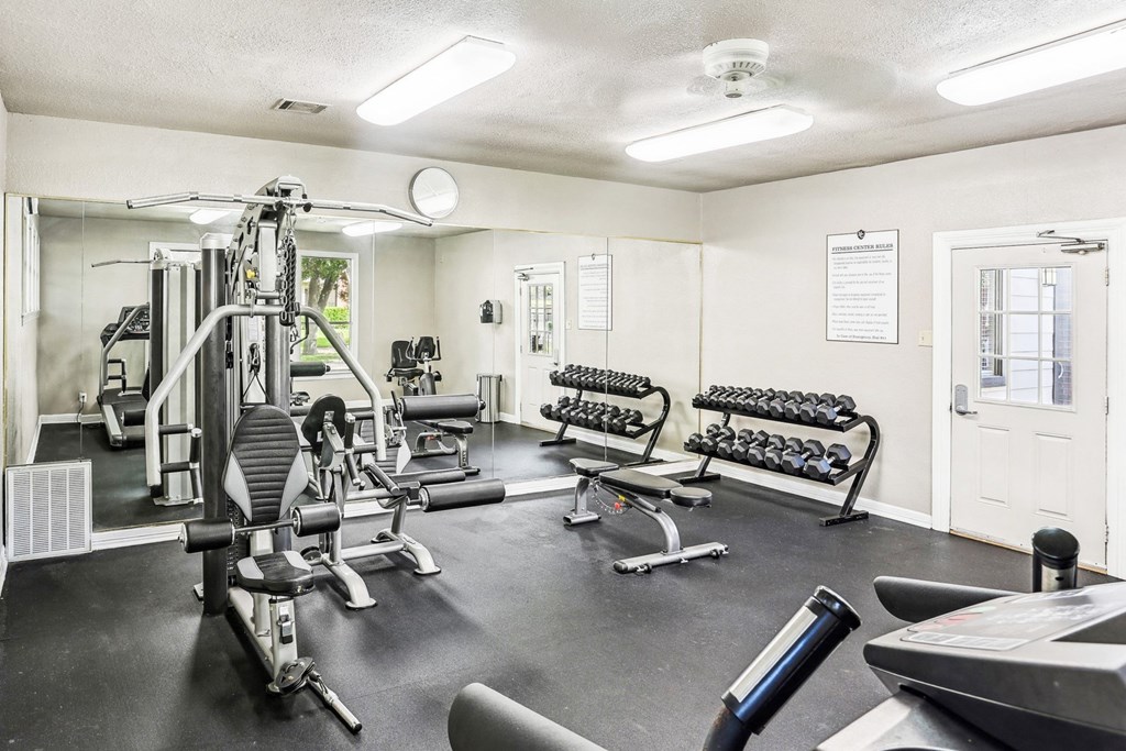 Fitness center with cardio machines and weights at Hunters Chase in Austin, TX