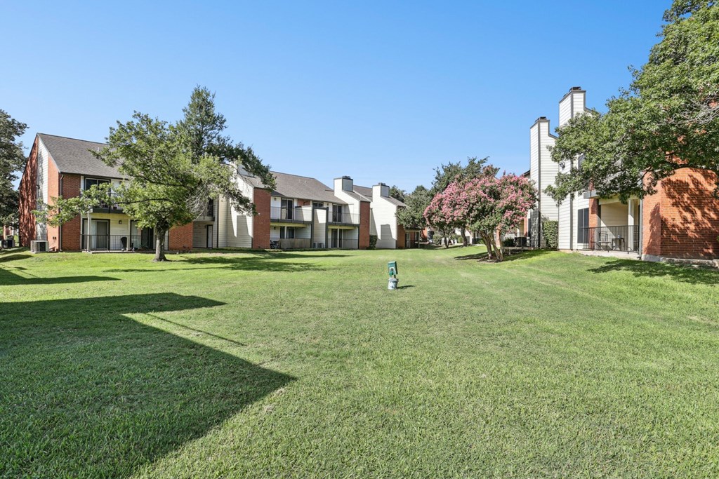 Well maintained green area with pet waste collection stations at Hunters Chase in Austin, TX