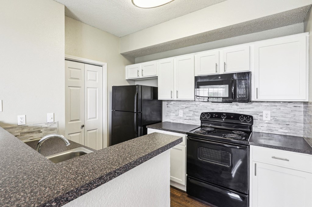 A2 floor plan updated kitchen with black appliances and white cabinets at Jefferson Creek Apartments in Irving, TX.