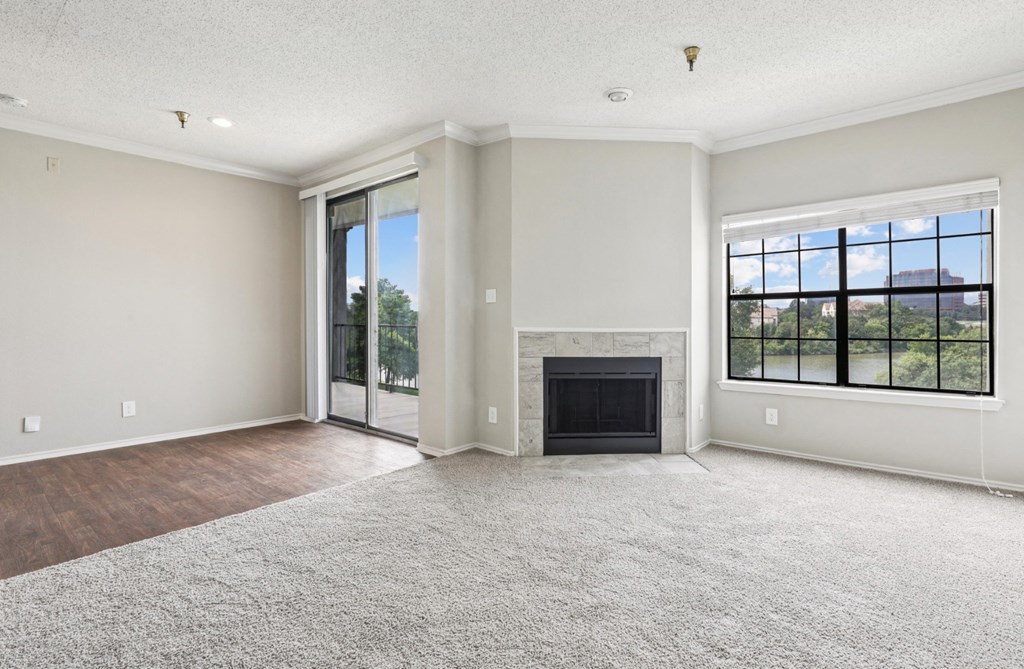 A2 floor plan living room with a fireplace and sliding glass doors that open to balcony at Jefferson Creek Apartments in Irving, TX.