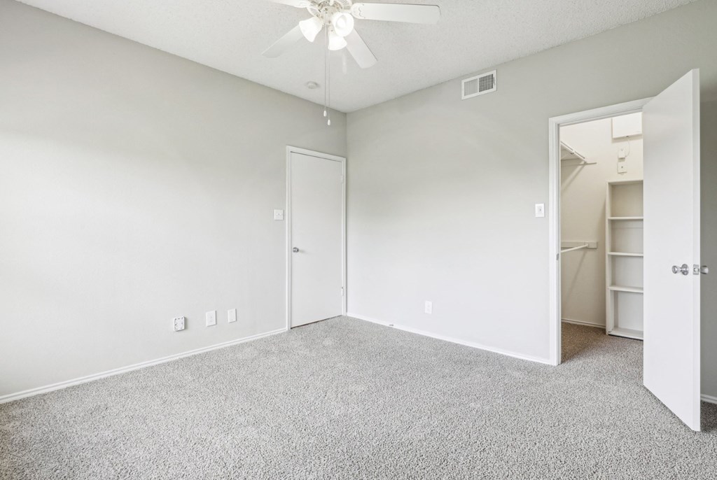 A2 floor plan bedroom with a  walk-in closet and a ceiling fan at Jefferson Creek Apartments in Irving, TX.