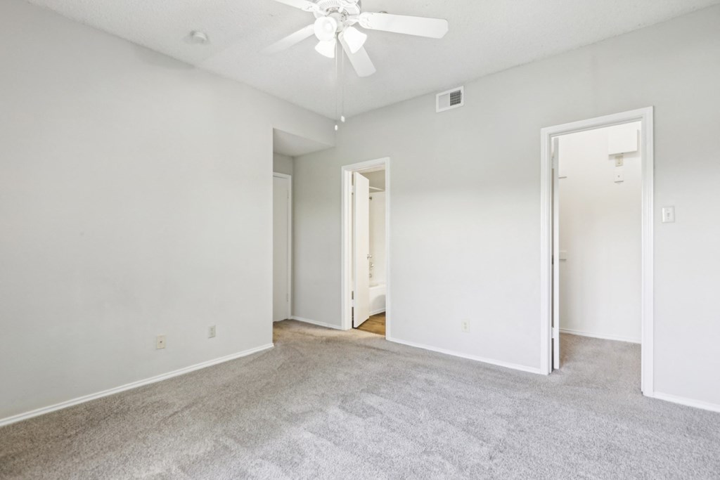 Second bedroom of B1 floor plan with walk-in closet and private bathroom at Jefferson Creek Apartments in Irving, TX.