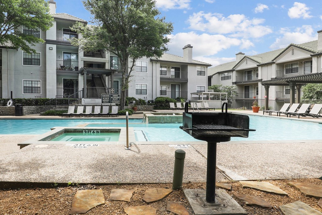 a swimming pool and a grill at Jefferson Creek in Irving, TX