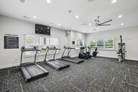 A fitness center with treadmills and strength training machines at Jefferson Place Apartments in Irving, TX