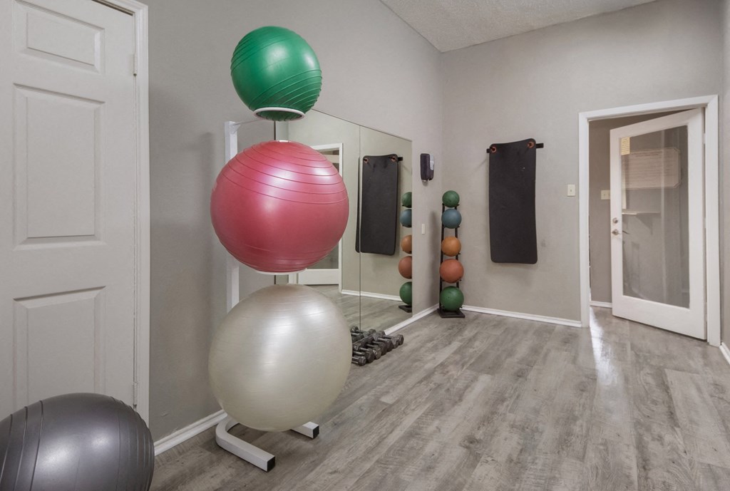 a room with a bunch of exercise balls and a mirror