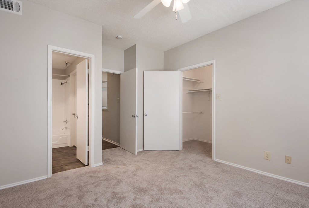a bedroom with a closet and a ceiling fan