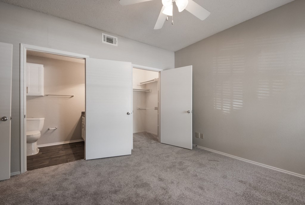 a bedroom with a ceiling fan and a closet