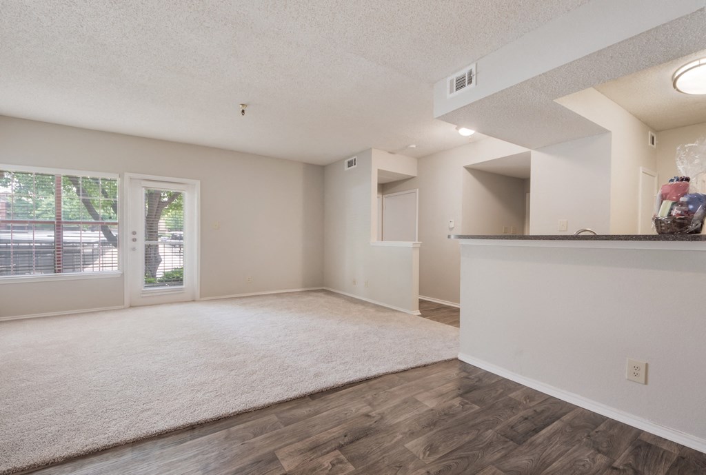 an empty living room with a door to a patio