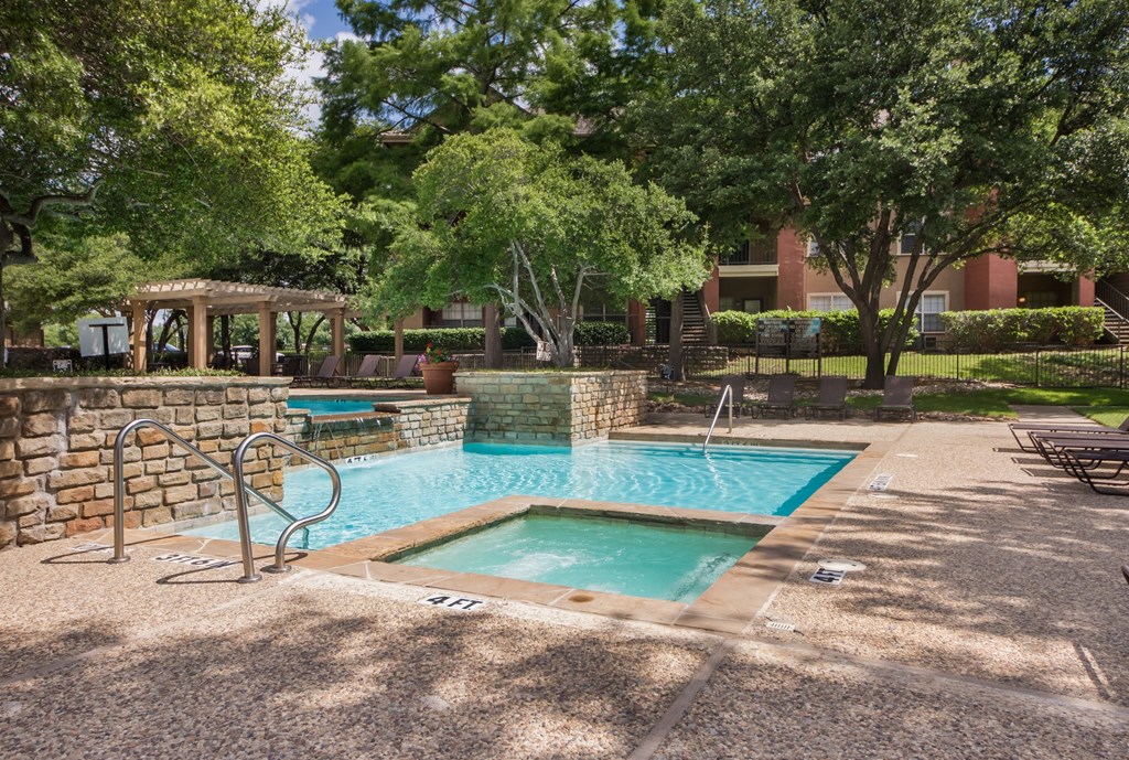 a pool and spa at a resort with trees