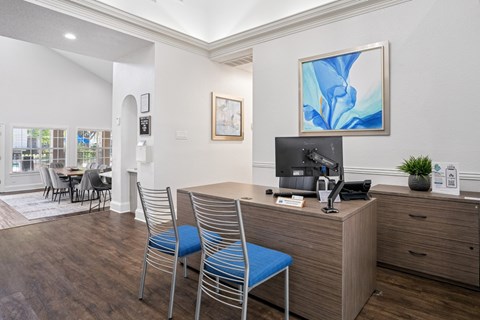 Leasing office with staff desk and two blue chairs at La Costa Apartments in Plano, TX
