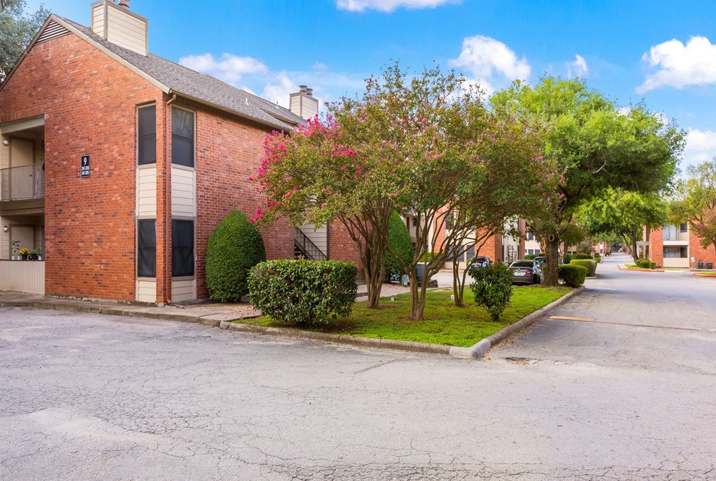 an empty street in front of a brick apartment building