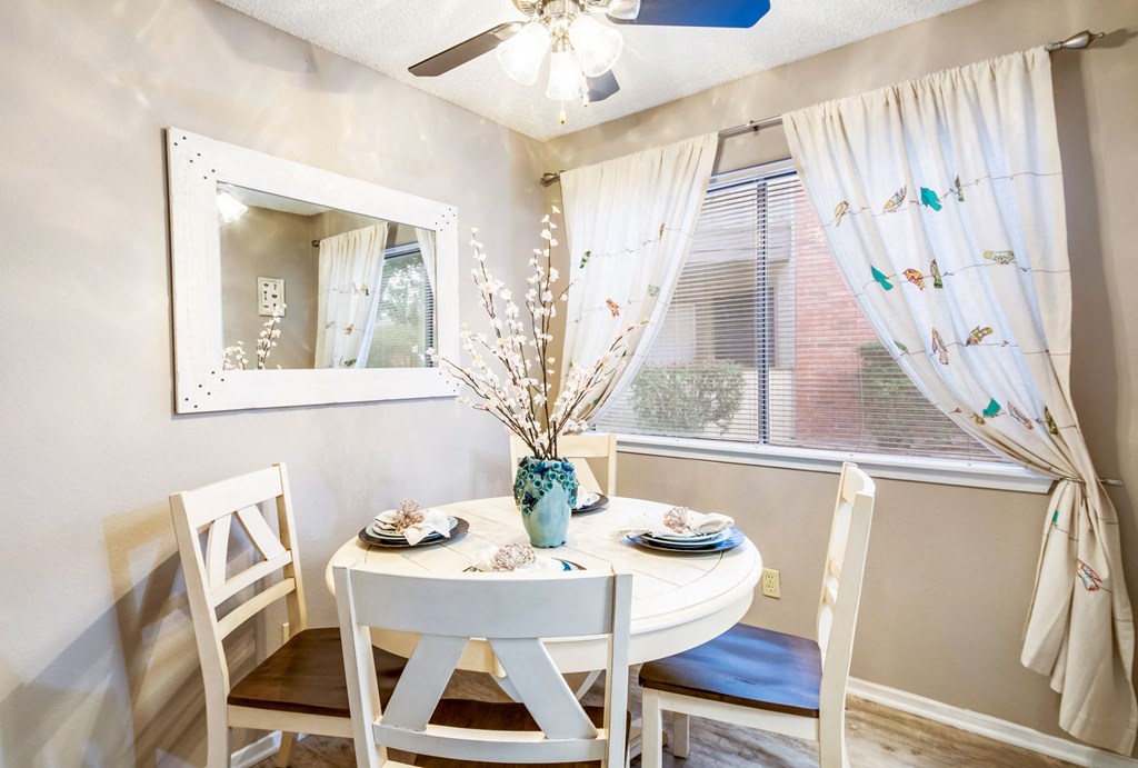 a dining room with a table and chairs and a window