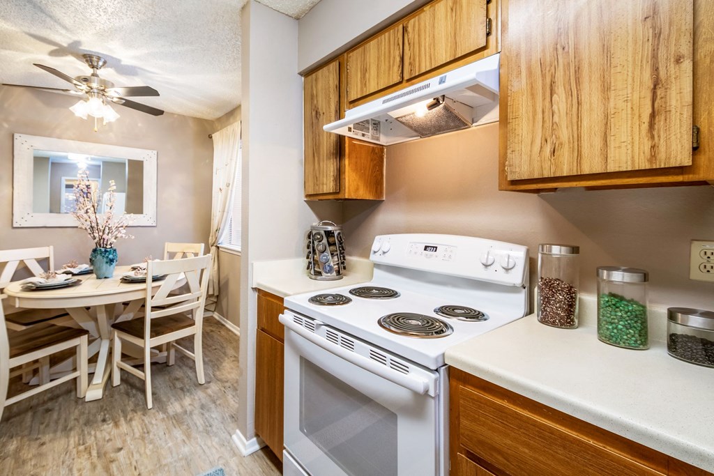 a kitchen with white appliances and a dining room table