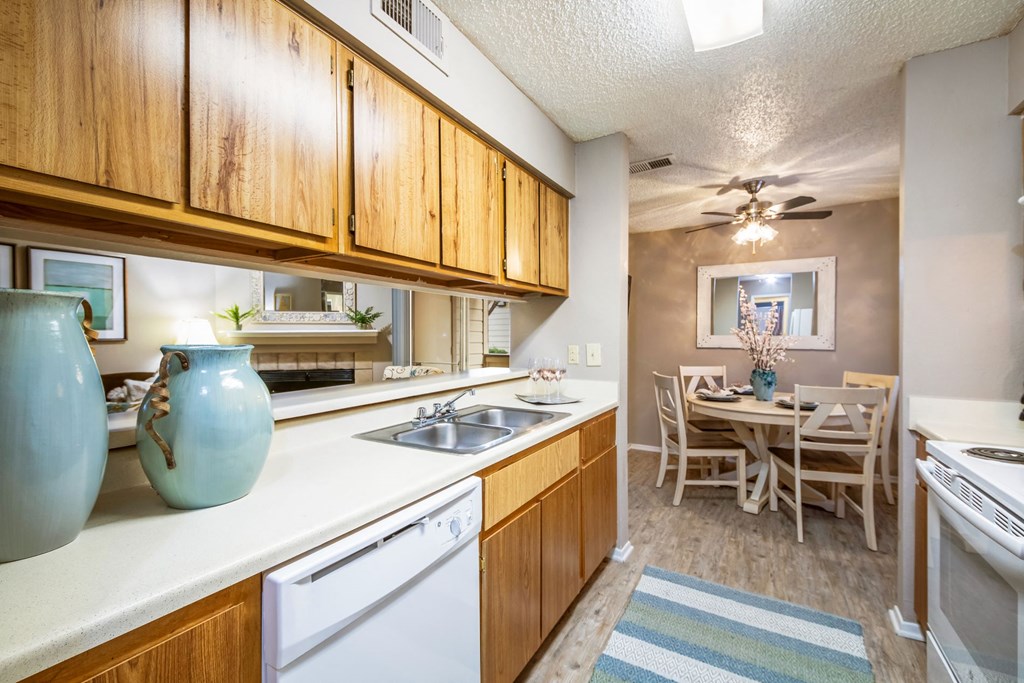 a kitchen with a sink and a dining room with a table