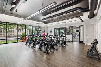 Spin room in our fitness center with exercise bikes, kettlebells and jump steps at Muse at Museum District apartments in Houston, TX