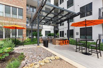 Outdoor grilling station under a pergola with two bbq grills at Muse at Museum District apartments in Houston, TX