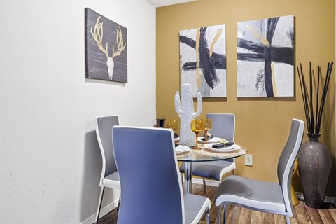 a dining room with a table and chairs and paintings on the wall