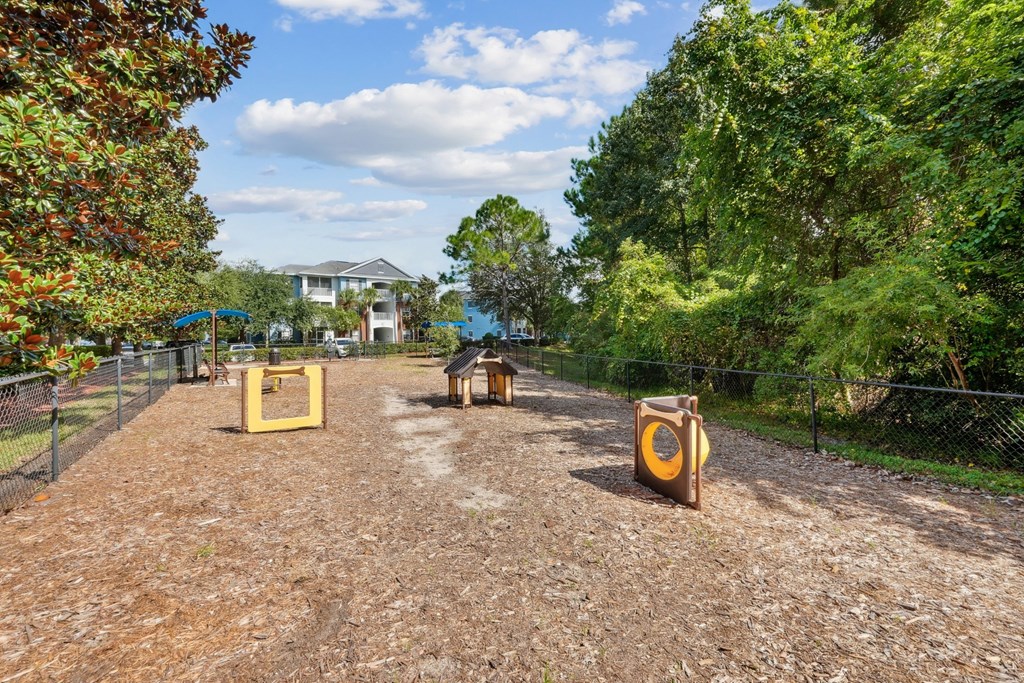 A fenced dog park with toys at Wynnfield Lakes Apartments in Jacksonville, FL