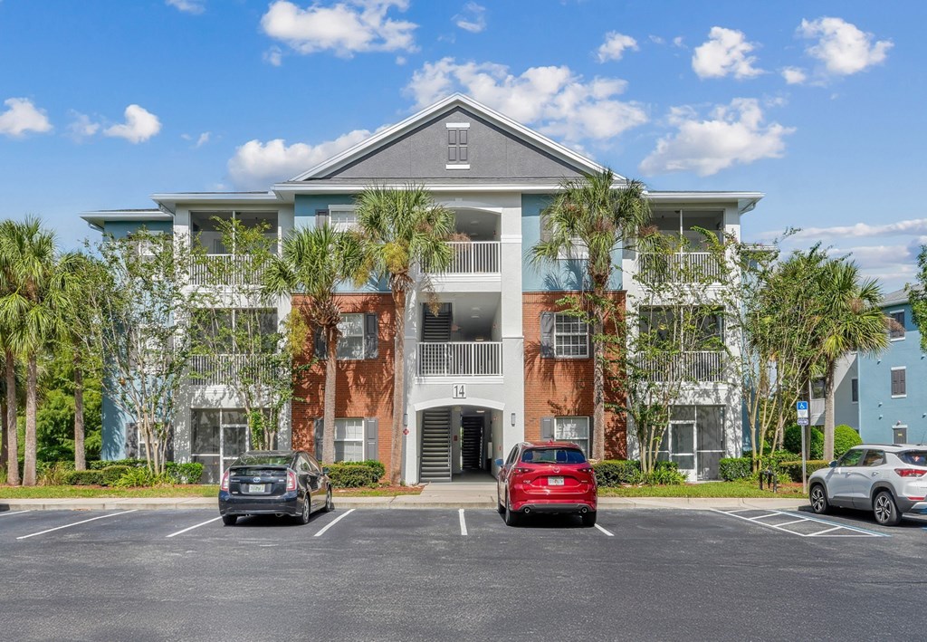 A multi-story apartment building with a parking lot in front at Wynnfield Lakes Apartments in Jacksonville, FL