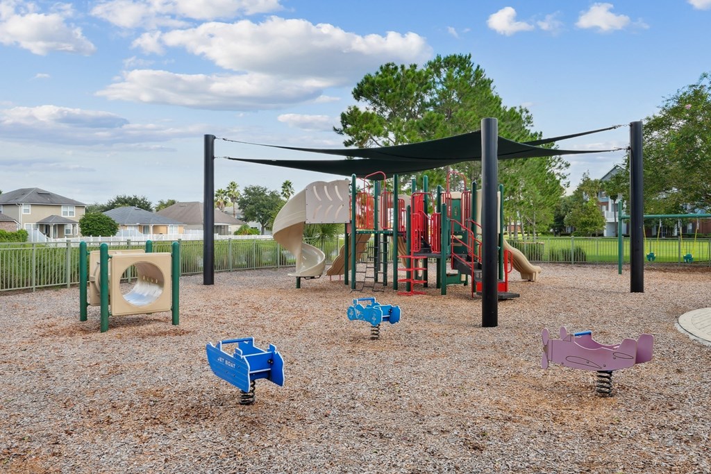 A playground with a slide and swings at Wynnfield Lakes Apartments in Jacksonville, FL