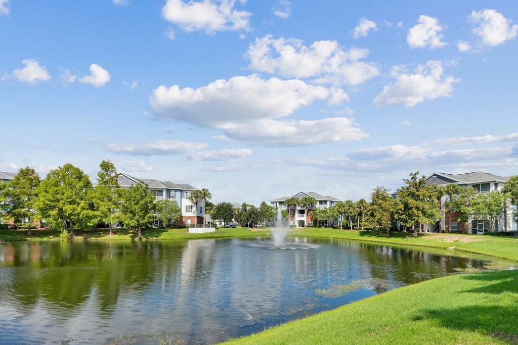 A serene pond surrounded by lush greenery at Wynnfield Lakes Apartments in Jacksonville, FL