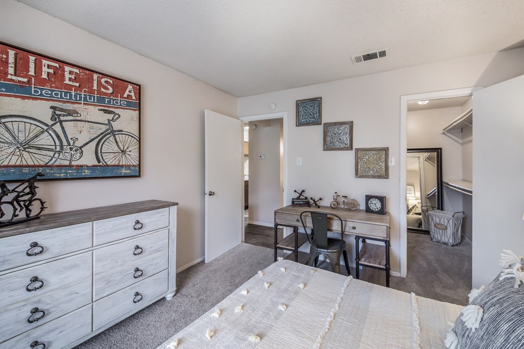 a bedroom with a bed and a desk and a living room