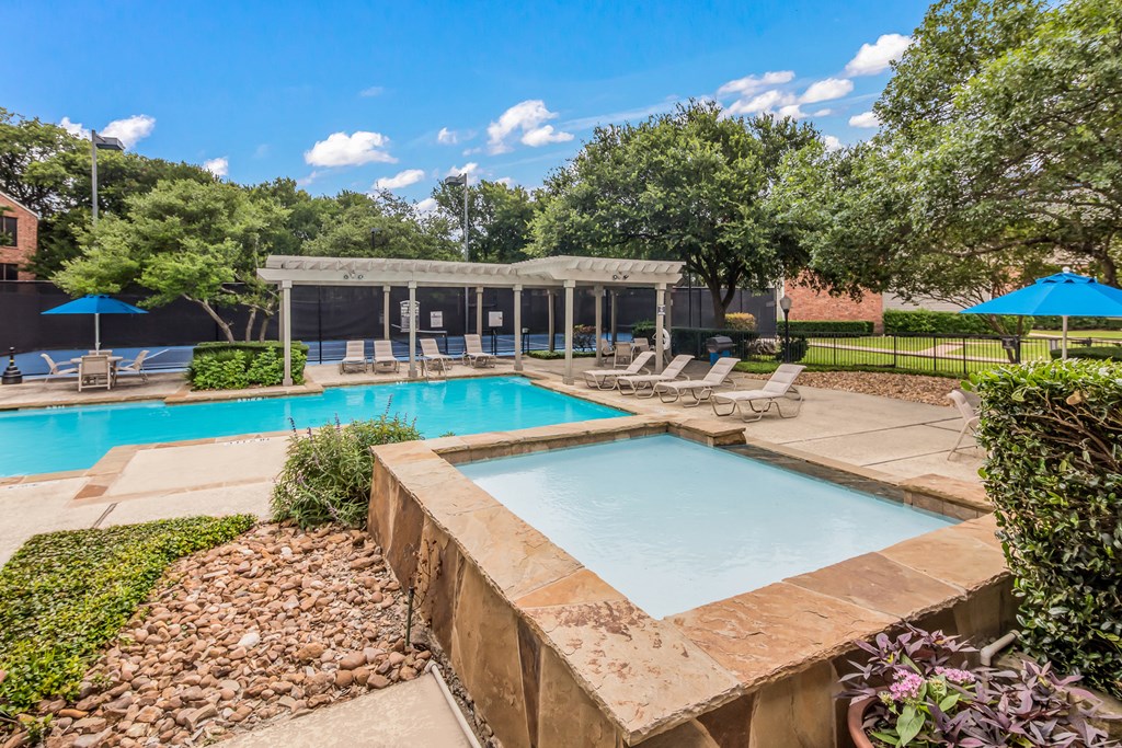 a resort style swimming pool with lounge chairs and a poolside pavilion