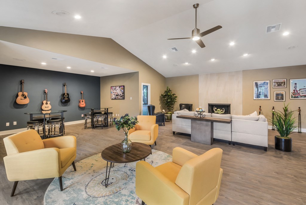 a living room with yellow furniture and guitars on the wall