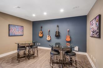 a room with a blue wall and four guitars hanging on the wall